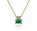 A birthstone pendant of an east-west-set emerald baguette topped with a round diamond suspended from a yellow gold chain